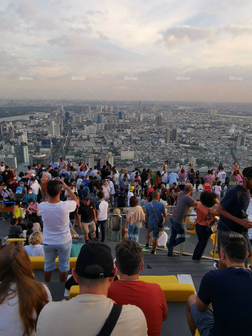 Nice evening. Beautiful scenery. Many people enjoy amazing city scenery. Skyscrapers and crowd.