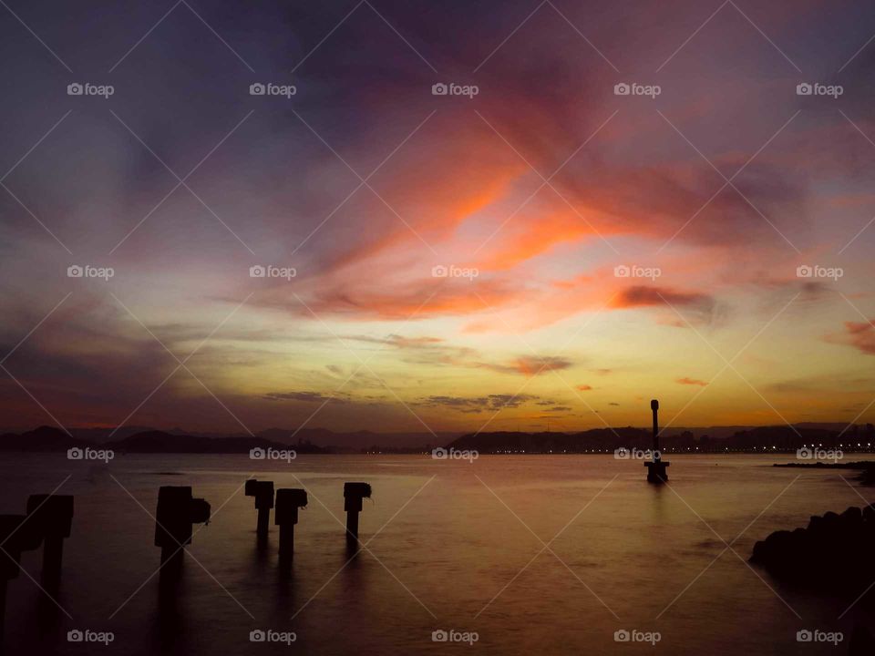 Sunset at Santos' Bay, Brasil. Beautiful Colors in the sky, very colorful, with purple, pink, yellow and orange tones. We see the sunset at the ocey