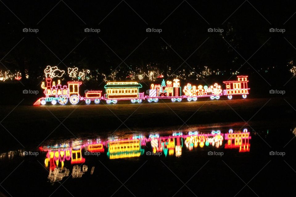 Christmas light train, reflection on pond