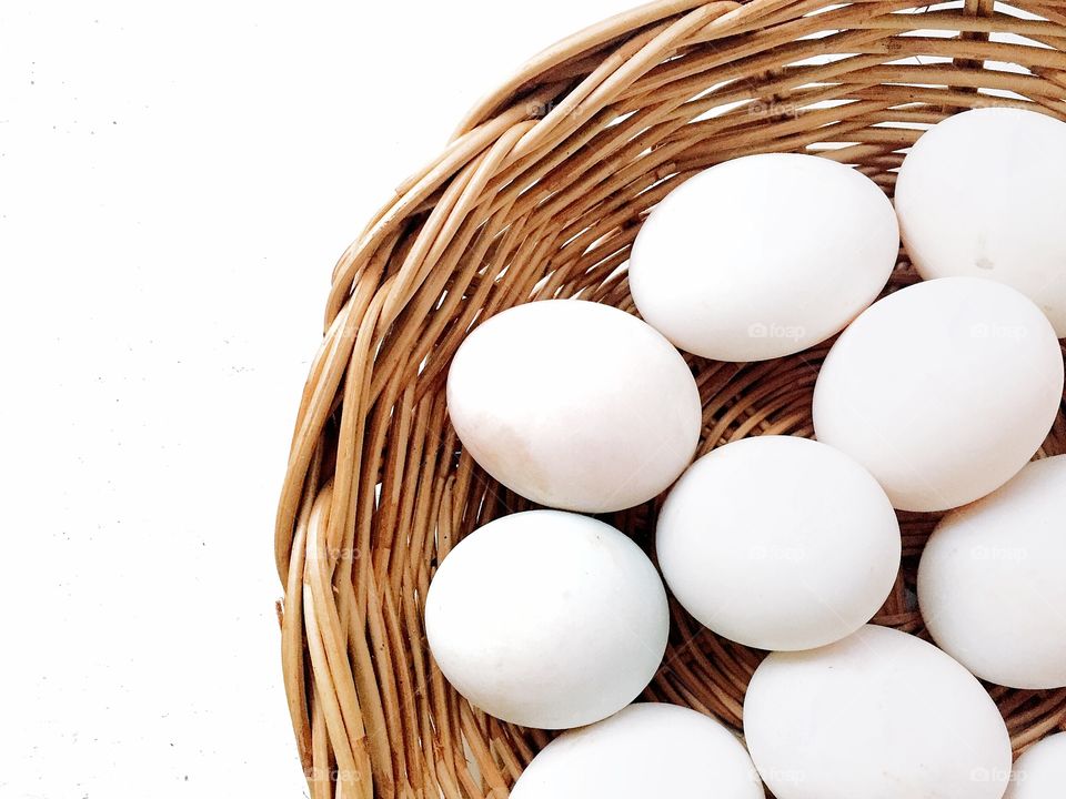 White duck eggs in a basket