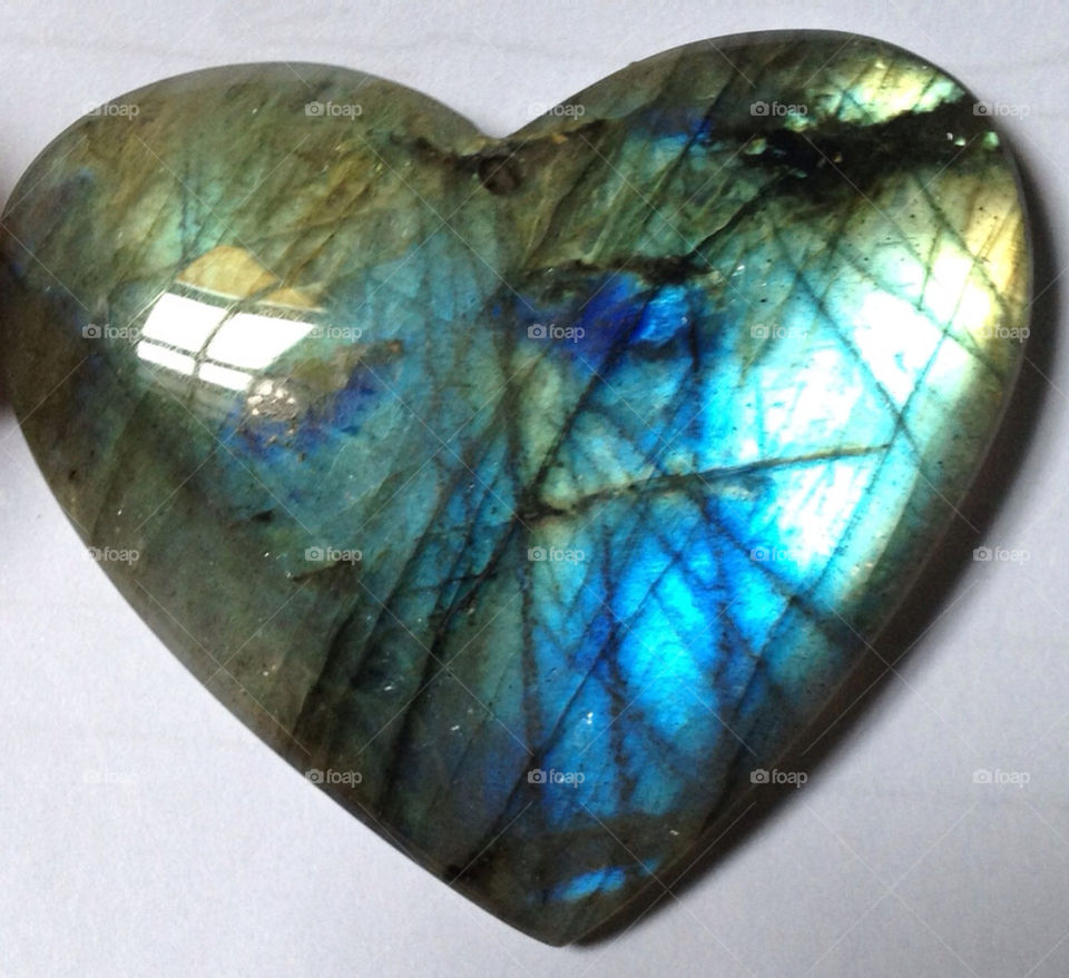 A heart-shaped rainbow moonstone (labradorite) gemstone.