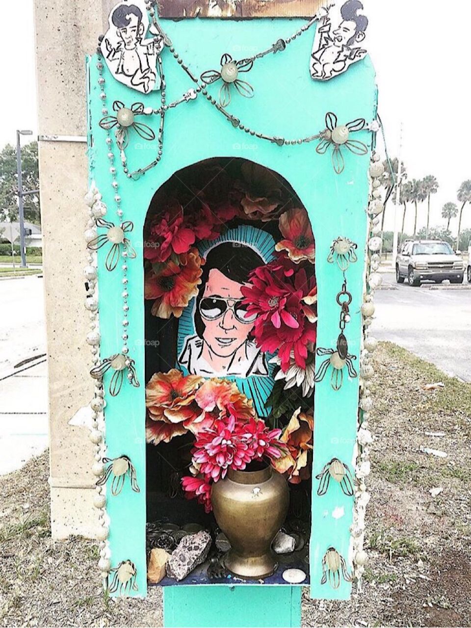 Funky decorated shrine to Elvis in a repurposed abandoned pay phone