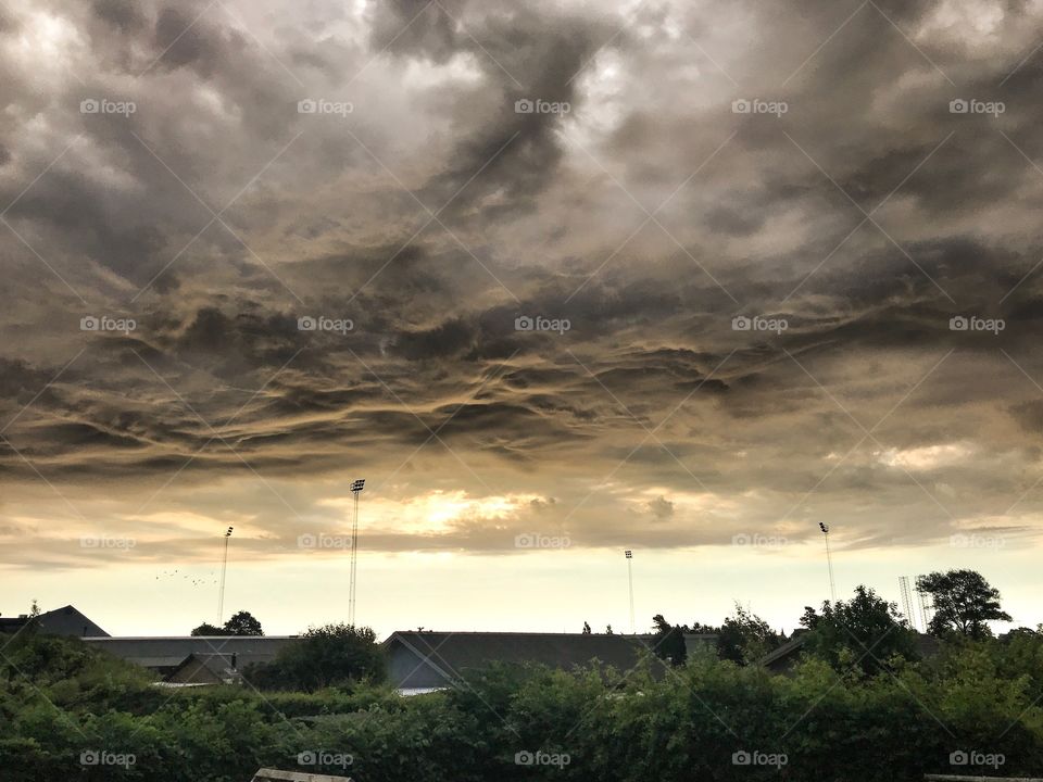 A dark but beautiful sunrise. The clouds moved around above city ground. The light was magical