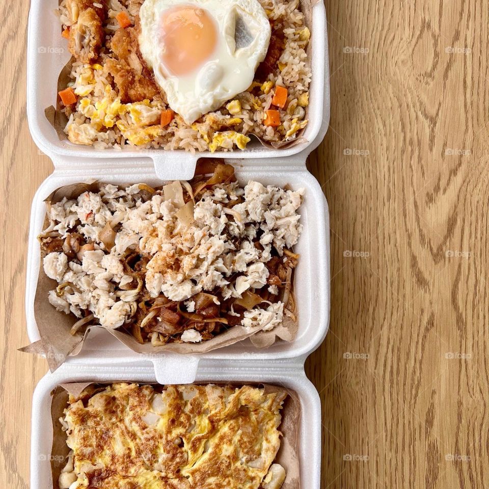 Local hawker asian dishes in cheesy floss carrot cake, crab meat char kway teow and fried rice with chicken and egg