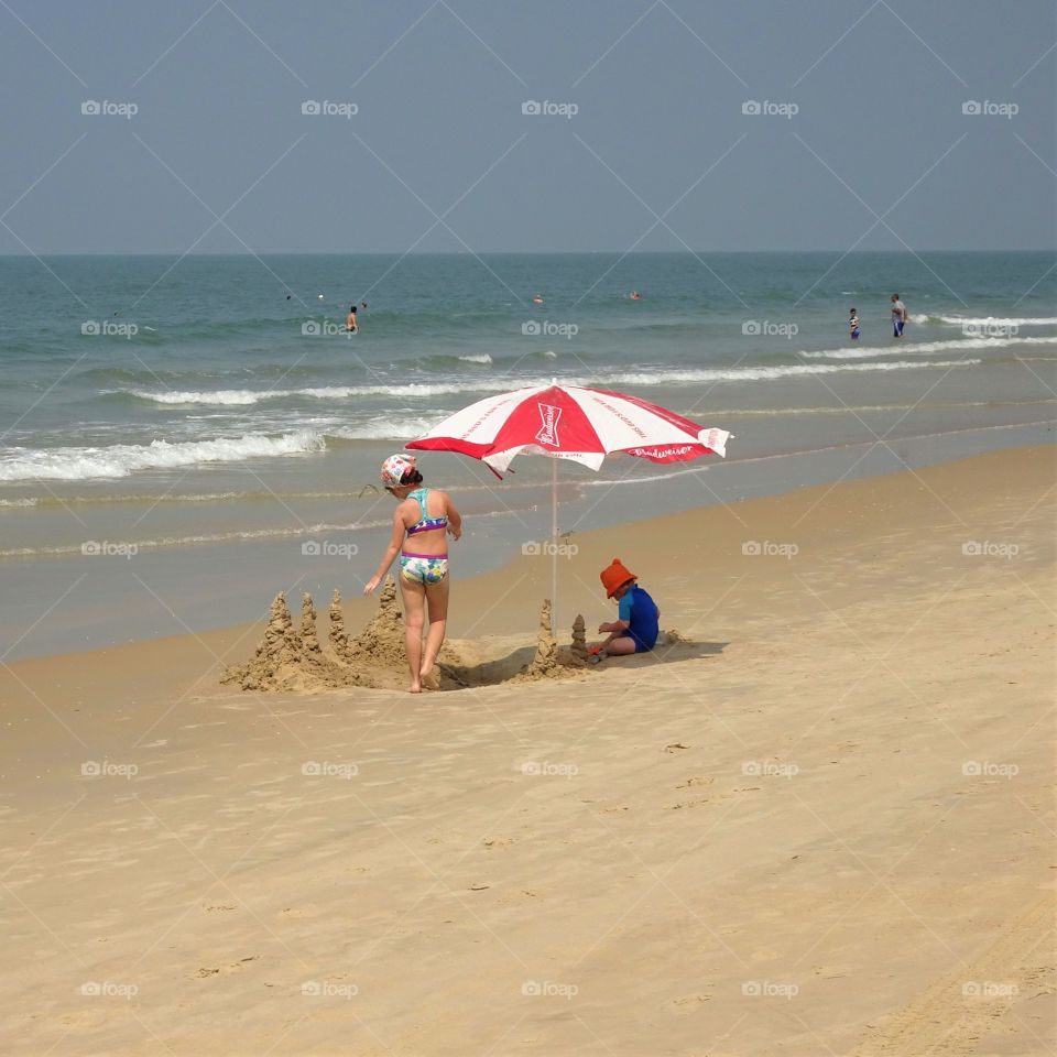 kids making castles on the sand in summer