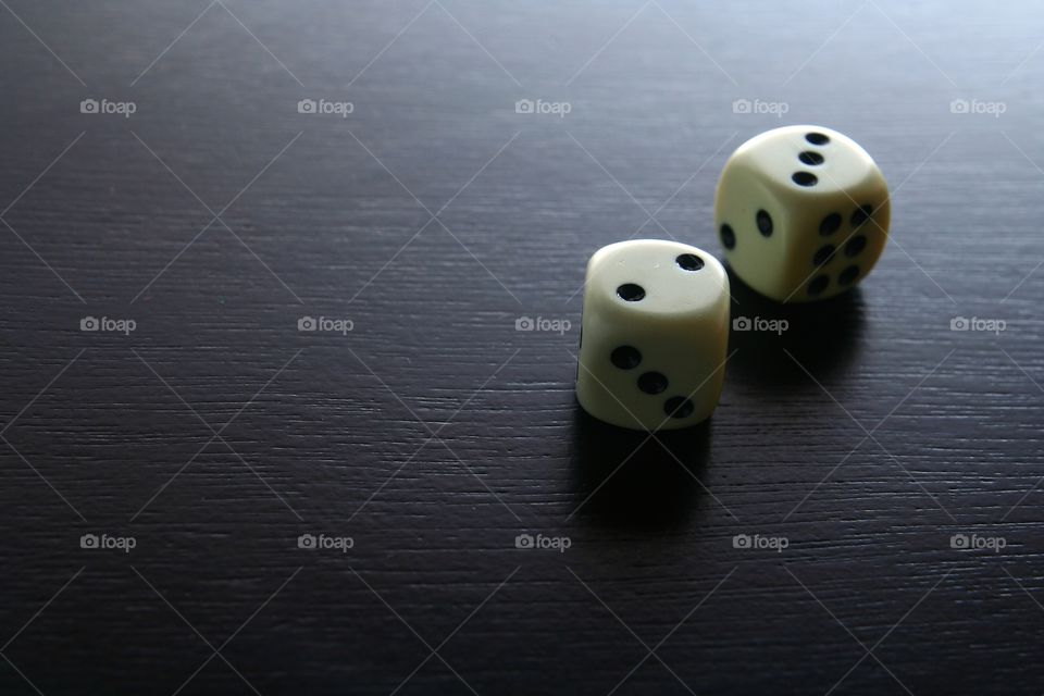 two white game dice. photo of two white game dice in a wooden table
