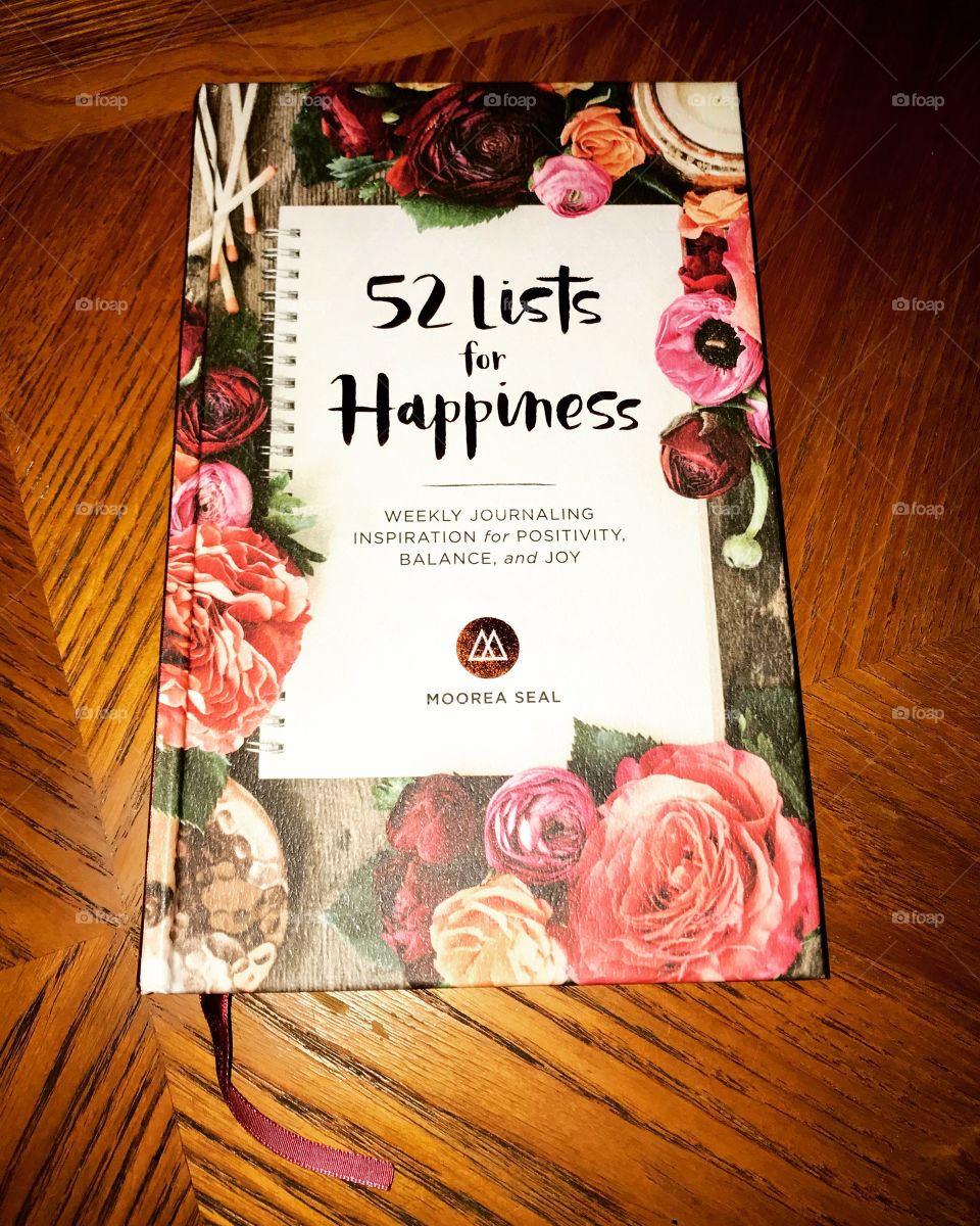 Journaling goals. 52 lists of happiness book on wood table 