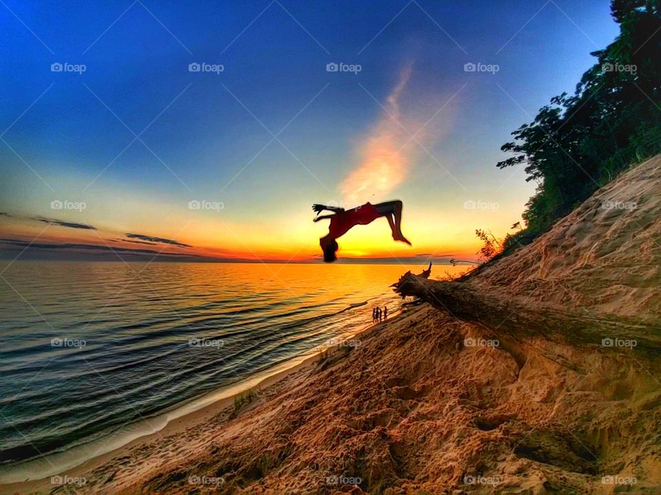 Silhouette of backflip on beach in sand dunes