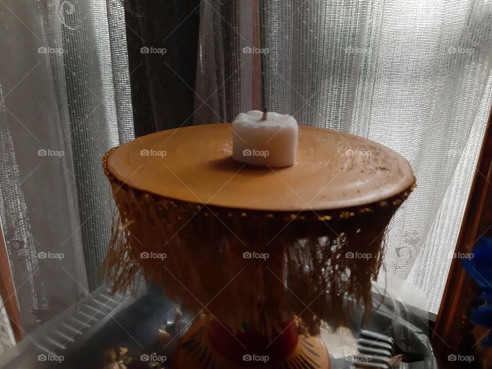 a mini white candle is placed on the round mini table. This photo was taken with Samsung Galaxy A7 by an amateur photographer.