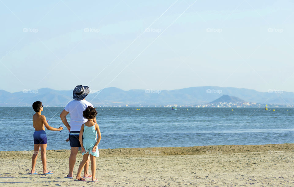 Family fling a kite at the seashore