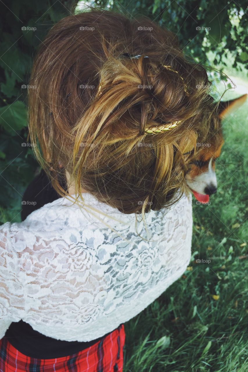 Summer style. Girl showing her hairstyle while holding her pup