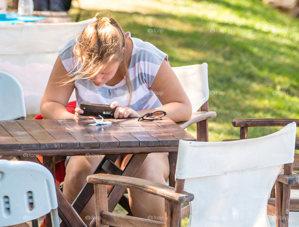 Teenager Girl On Vacation Using Her Cellphone Outdoors
