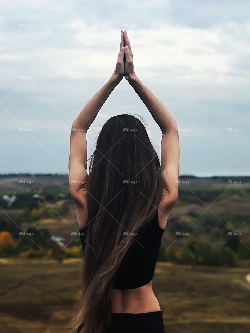 Young woman with long hair doing yoga outdoors 