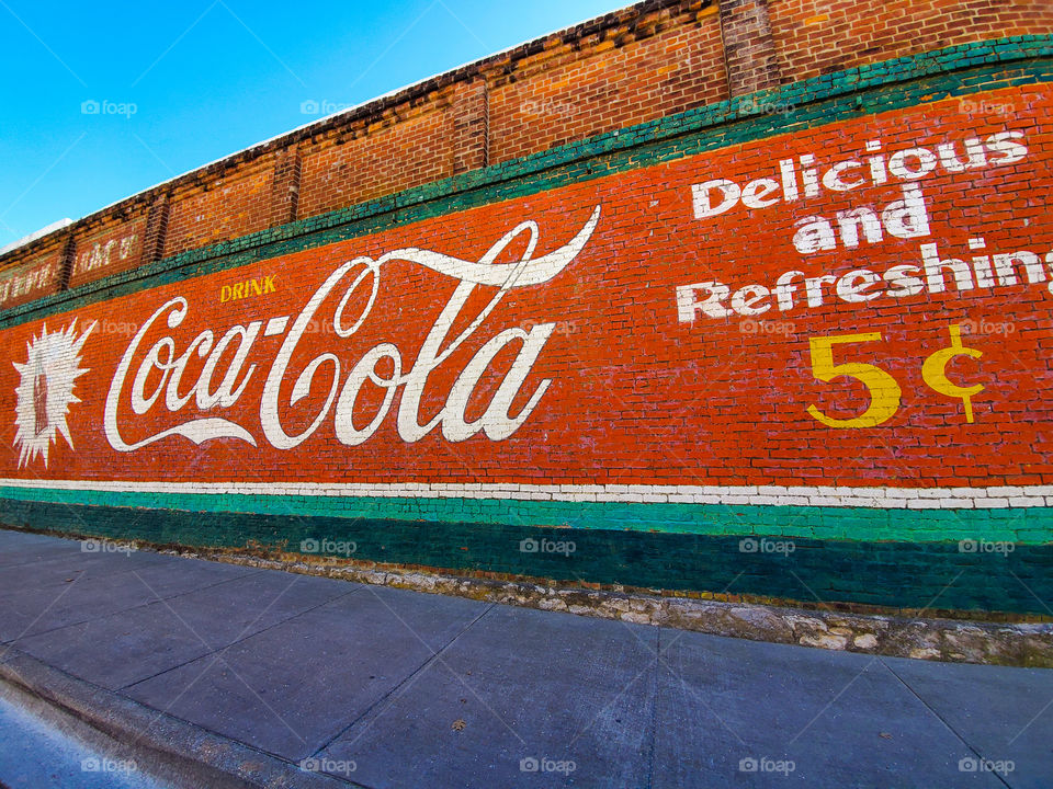 An old Coca Cola advertisement painted on the side of the building recalls a time when it only cost five cents for a bottle of cool refreshment