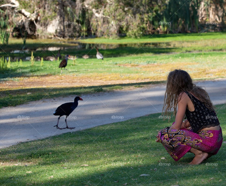 Lady enjoying the wild birds at a wetlands in Perth Australia