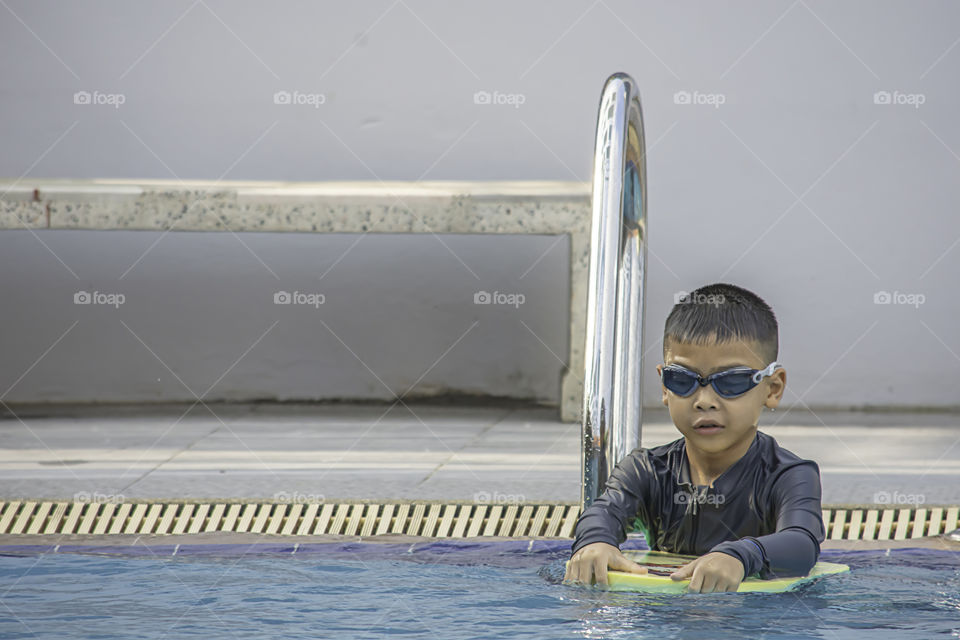 Asean boys are swimming in the pool.