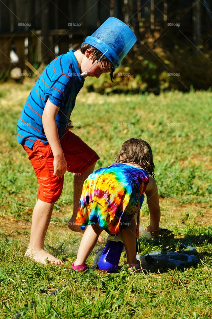 Kids Playing With Water In The Backyard