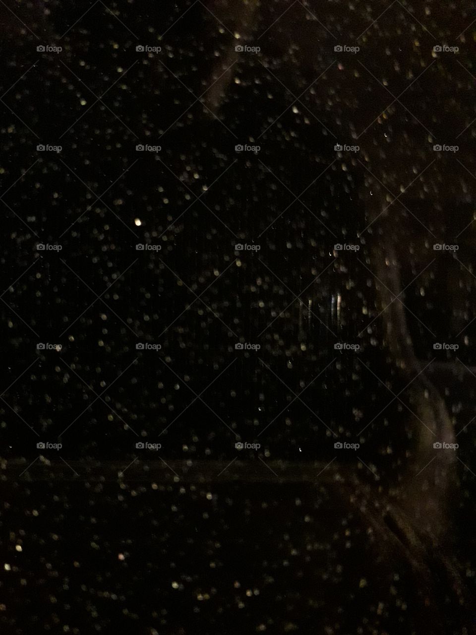 night storm - rain drops at a winow mesh