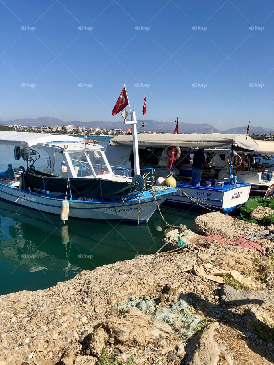 На этой удивительной фотографии вы увидите причал с рыбацкими лодками , а в дали виднеются величественные горы