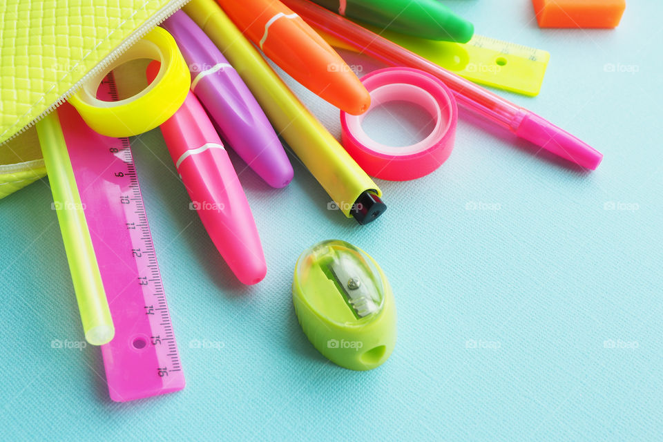 colorful bright stationery fall out of the pencil case on the table