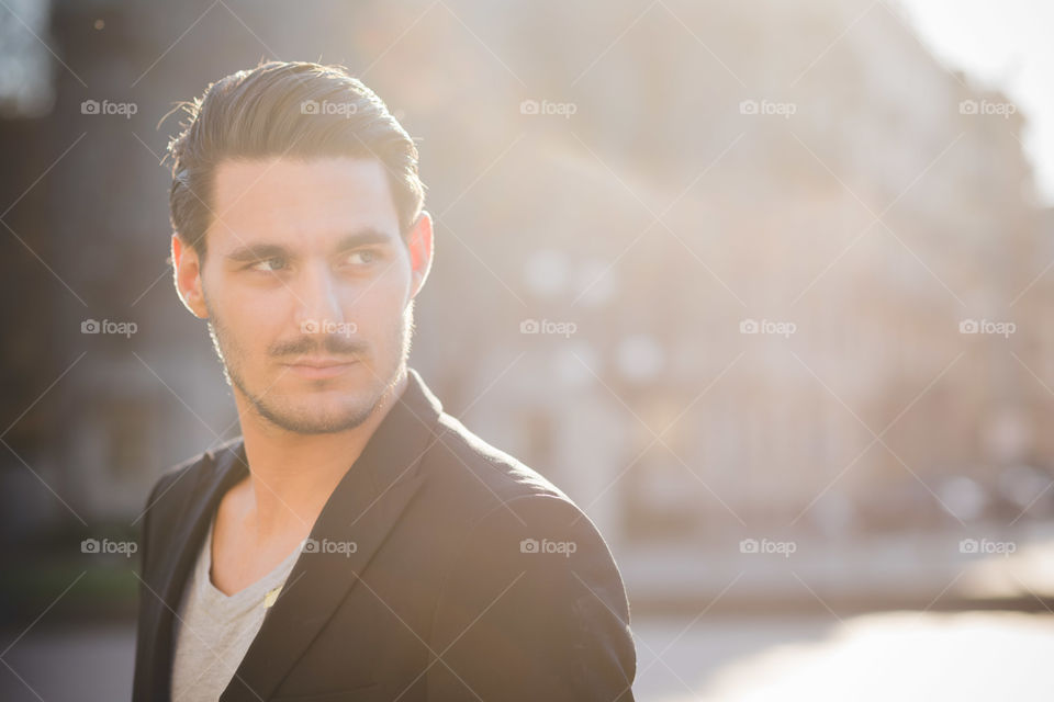 young handsome model man bearded in the streets of Milan