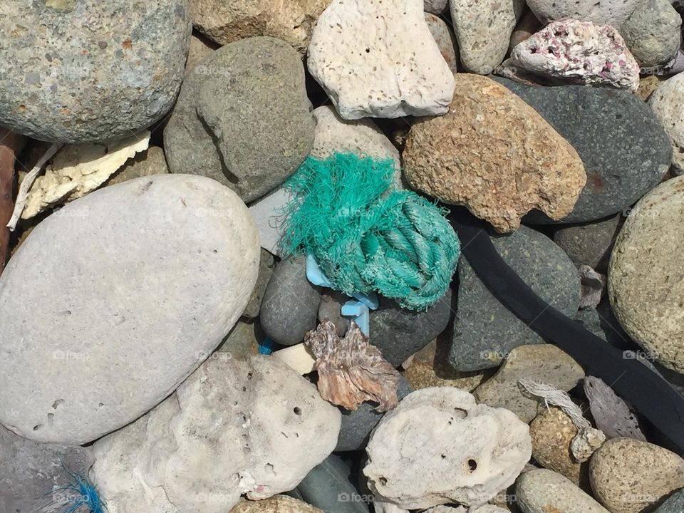 Trash on the beach, rocks and discarded garbage on the beach, paradise lost 