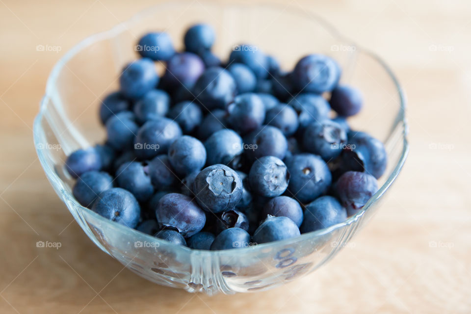 Glass bowl filled with fresh blueberries 
