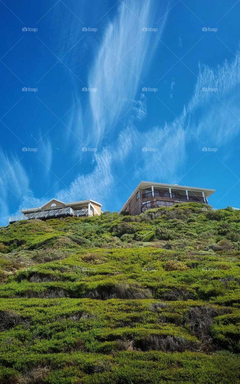 house on the hill overlooking the ocean.