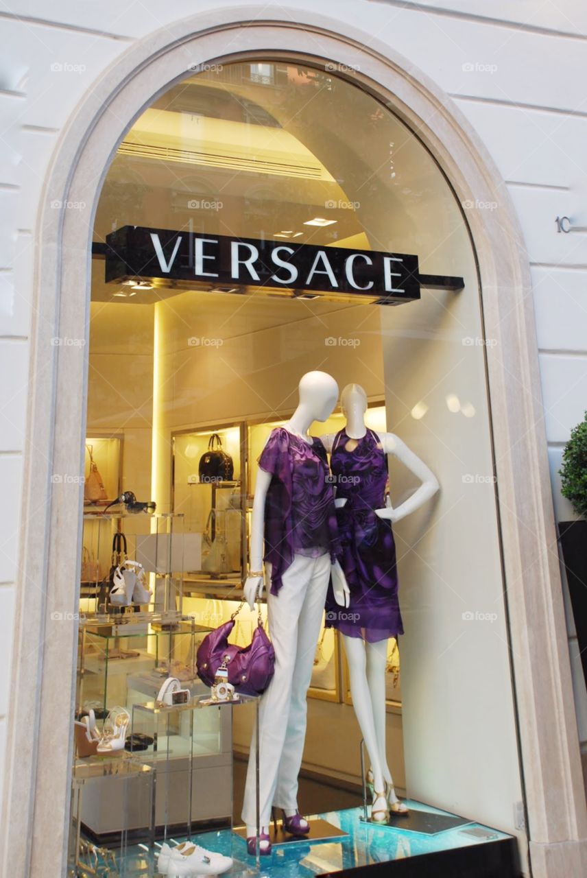 A Versace store window in Rome. A store window with purple Versace women's fashions displayed in Rome