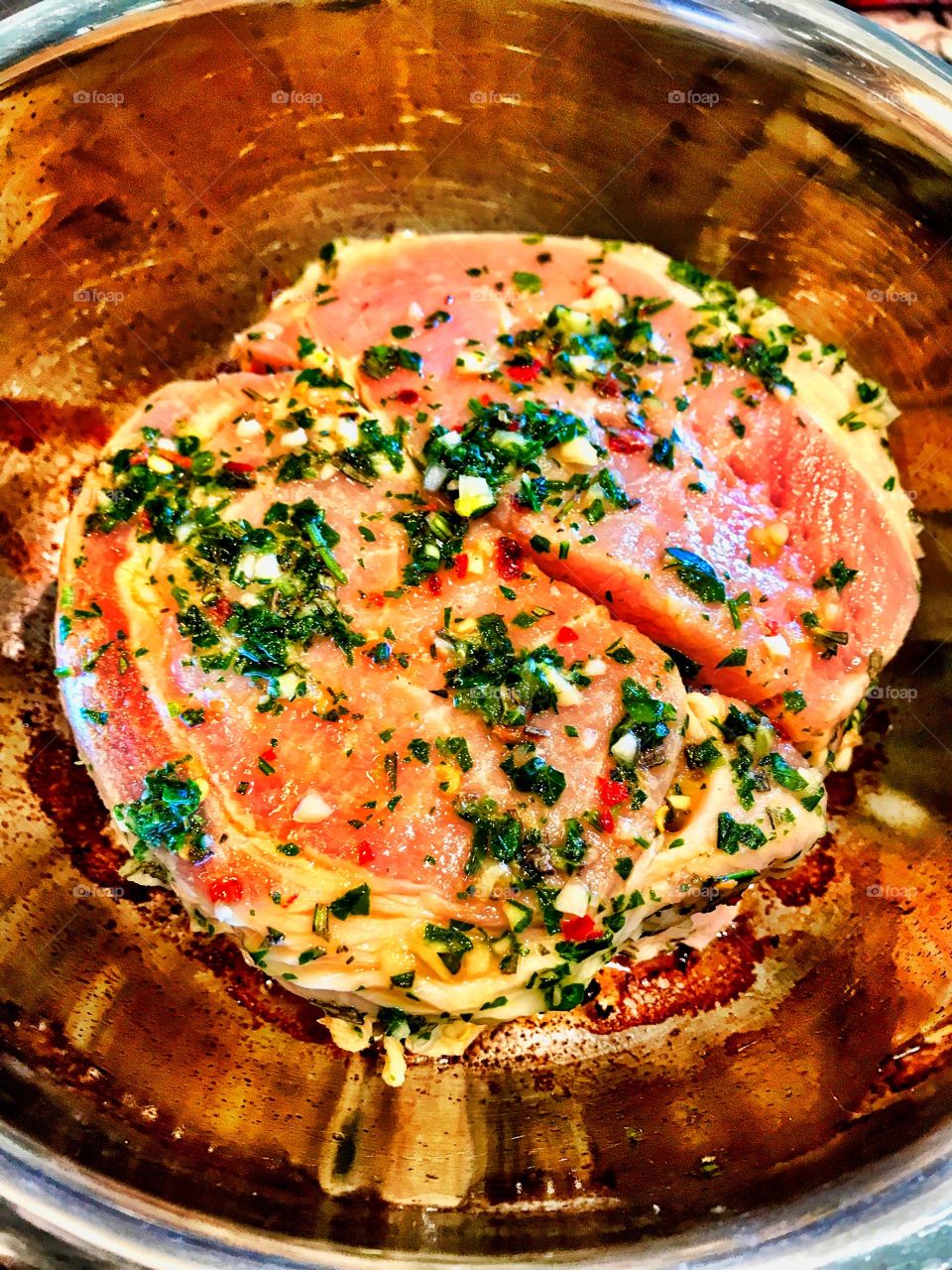 Pork roast in a pan ready to cook.  Marinated: Orange juice, rosemary, salt, black pepper, crushed red peppers, garlic