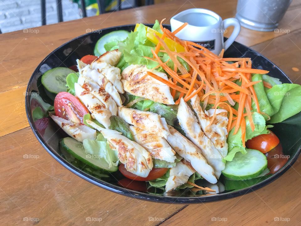 Chicken salad on wooden table. Healthy food. 