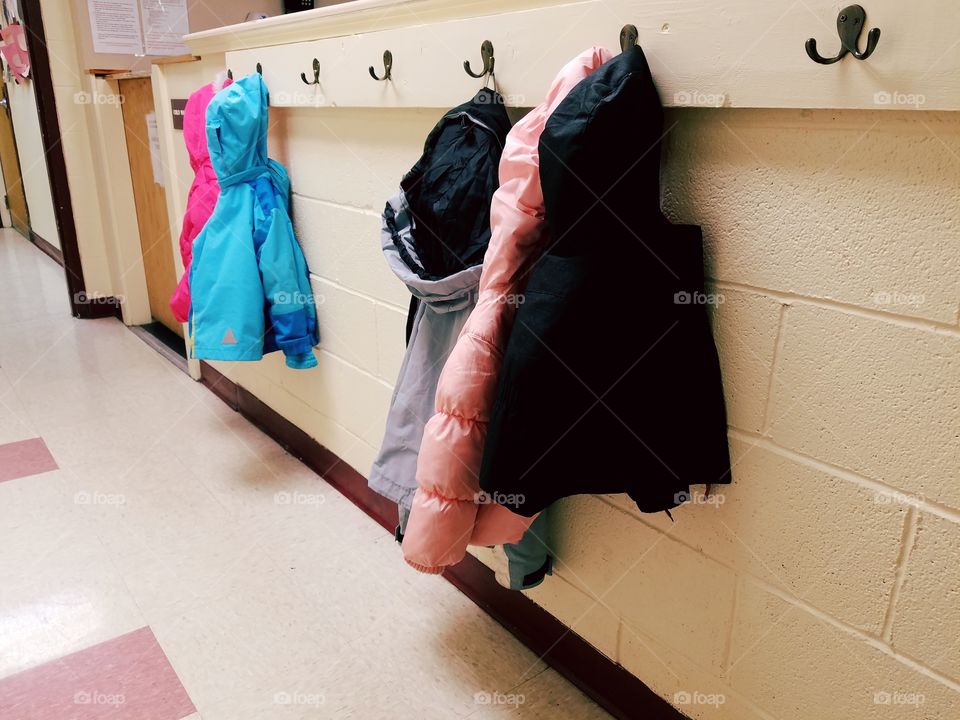 Daycare children's coats hanging.