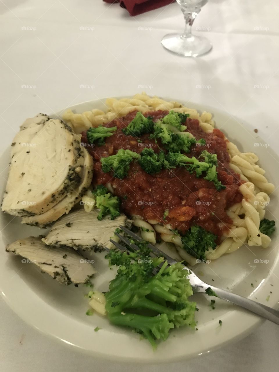 Amazing meal of pesto chicken over marinara pasta with broccoli 