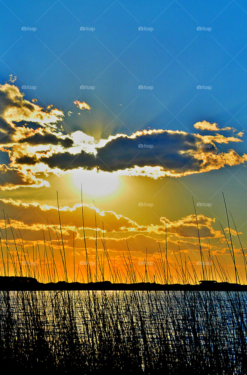 Sunset over the bay with explosive sun rays piercing through the gallant puffy clouds!