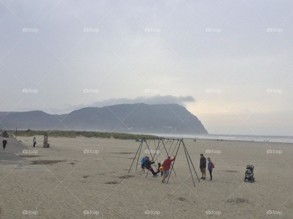 A Family Playing on the Swings at the Beach in Seaside Oregon 