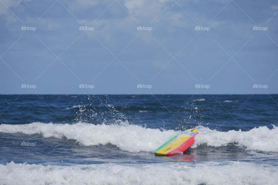 Surfboard clashing on water 