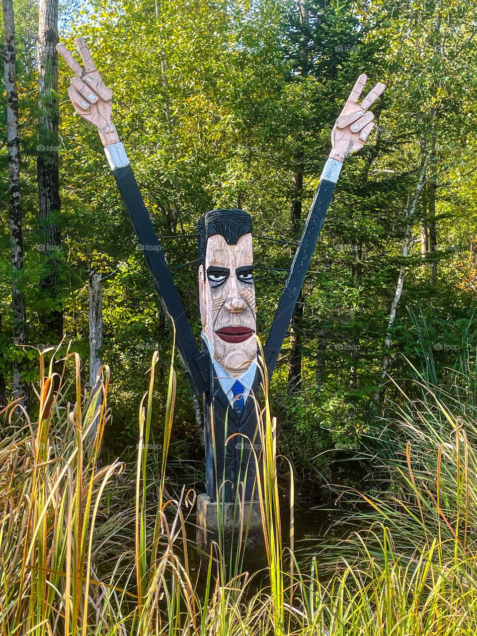 Caricature statue of US President, Richard Nixon in a small pond , by late folk artist, Bernard Langlais.