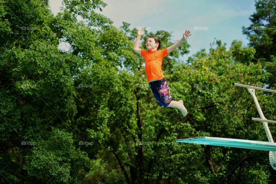 Boy Jumping Off A Diving Board