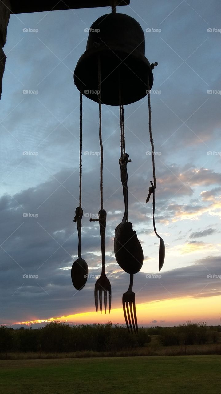 Handmade windchime dangling in the Oklahoma breeze with an incredible sunset behind.