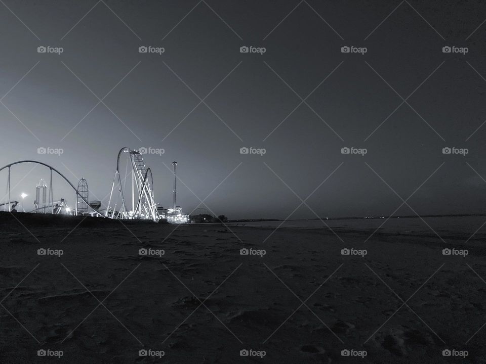 Black and white at night of glowing roller coaster from sandy Blake Eerie show in Ohio