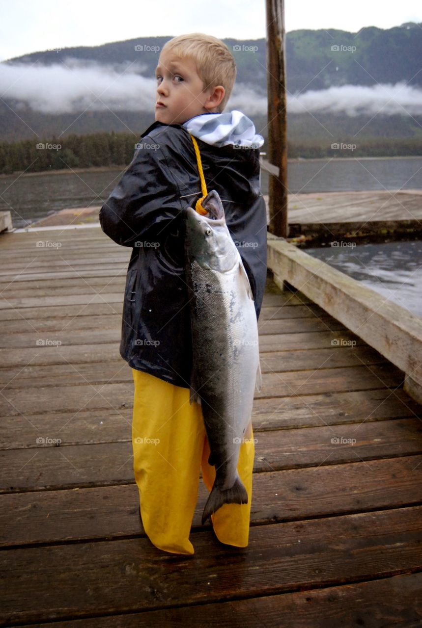 Child with Alaskan salmon over shoulder 