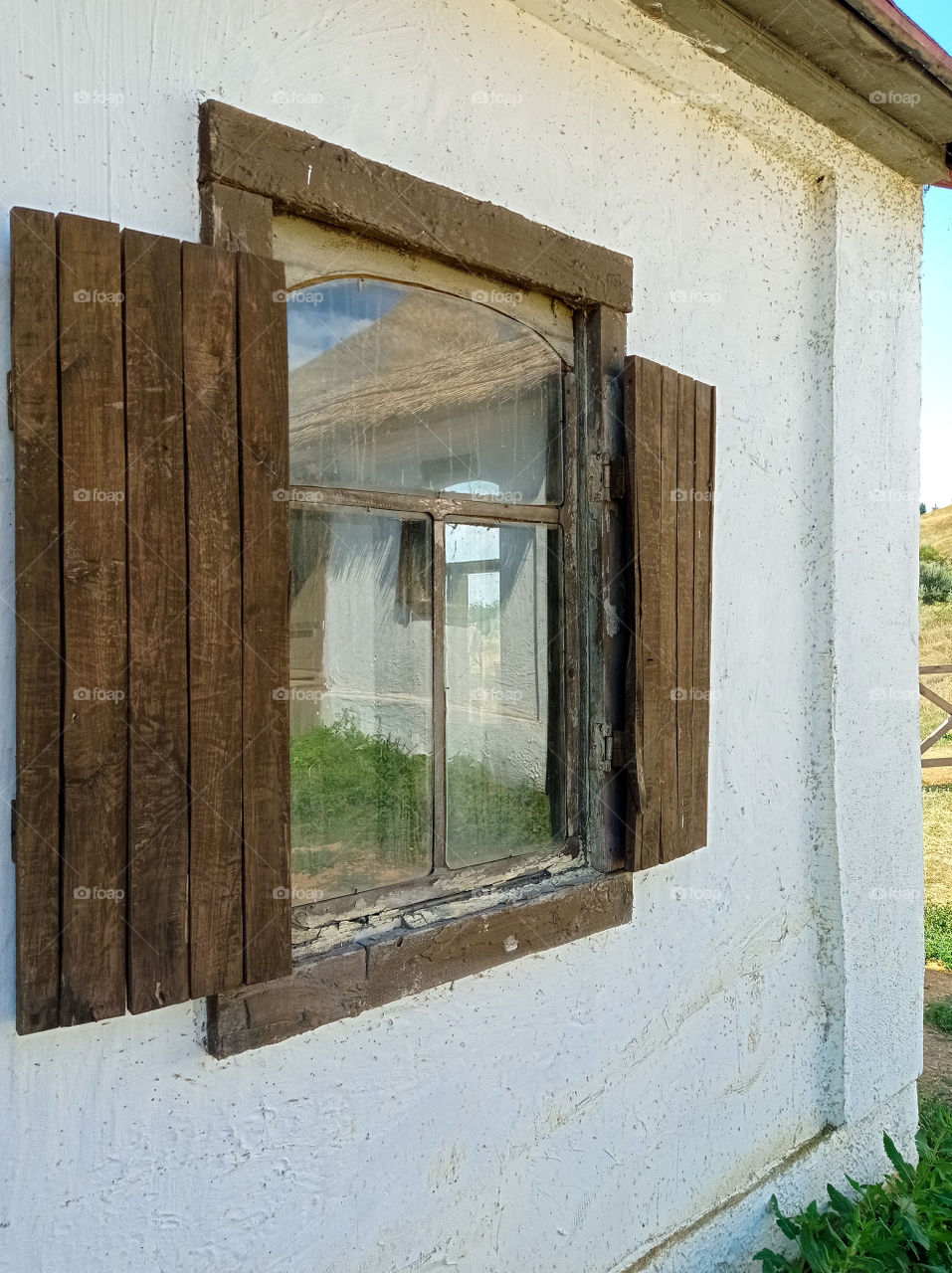 a village house reflected in a window