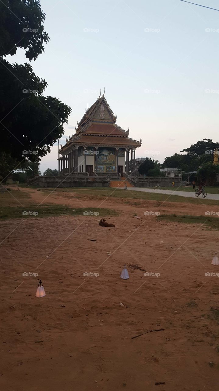 Temple in Cambodia at dusk, red earth, sun beginning to set evening time