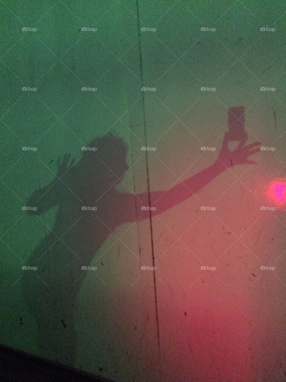 Shadow image of a person holding a smart phone. 