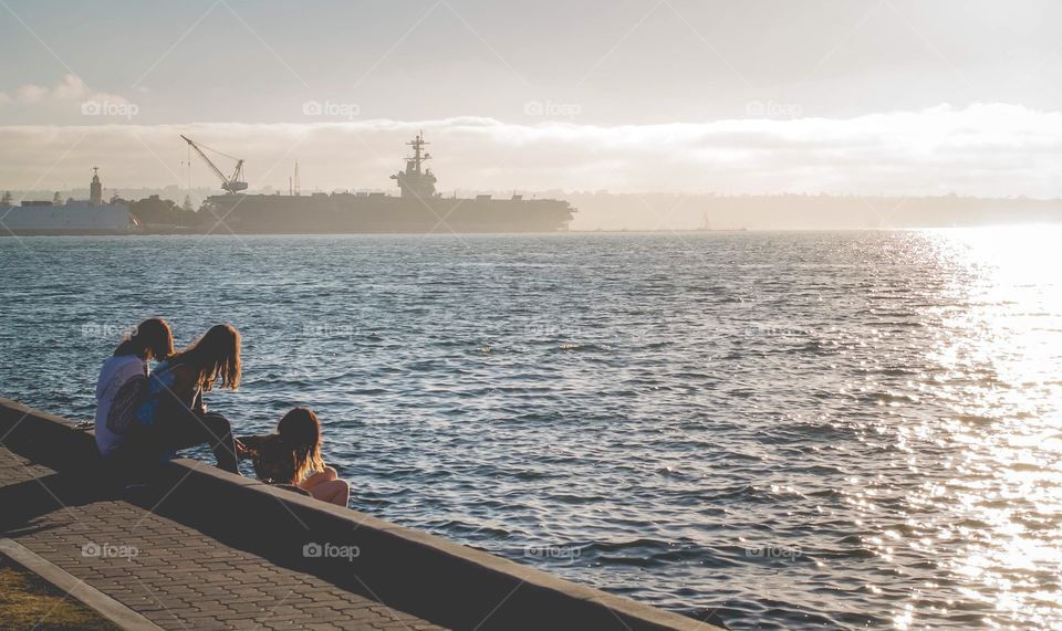 Group of friends sitting near sea