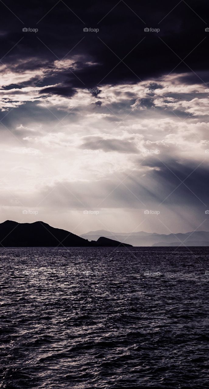 A beautiful sea view with the suns rays shining through the clouds 