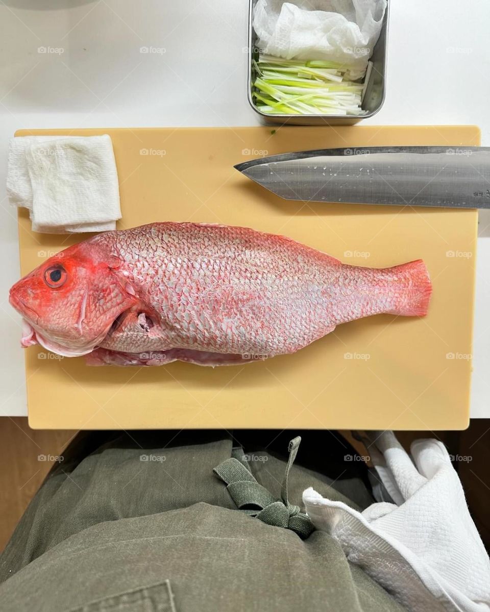 Chef prepares fish for clients, chef making fish fresh for dinner, chef’s setup in kitchen, fish on cutting board 