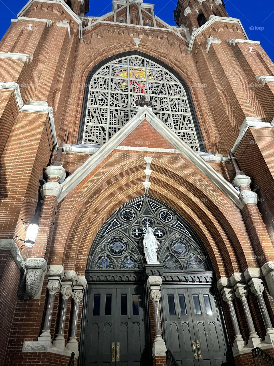 A large, antiquated church from below . Night time, brick, stained glass