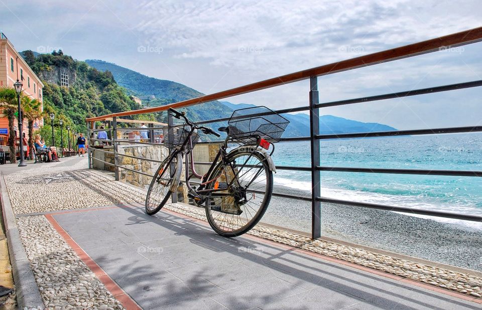 Bike above the sea. A single bike rests on a railing above a beautiful beach and aqua colored ocean 