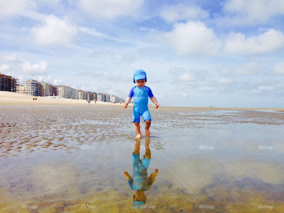 Small boy walking on sandy beach